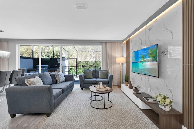 living area with visible vents and wood finished floors