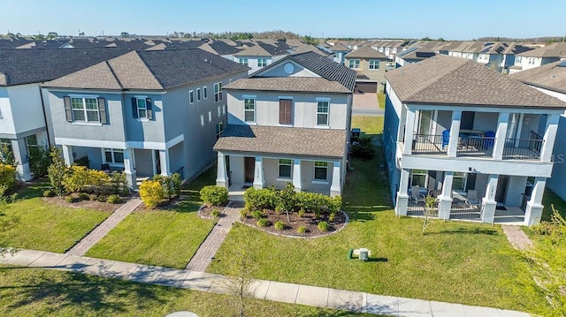 view of front of home with roof with shingles, a residential view, a front lawn, and stucco siding