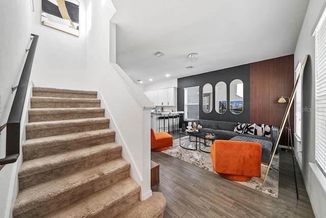 staircase featuring visible vents and wood finished floors