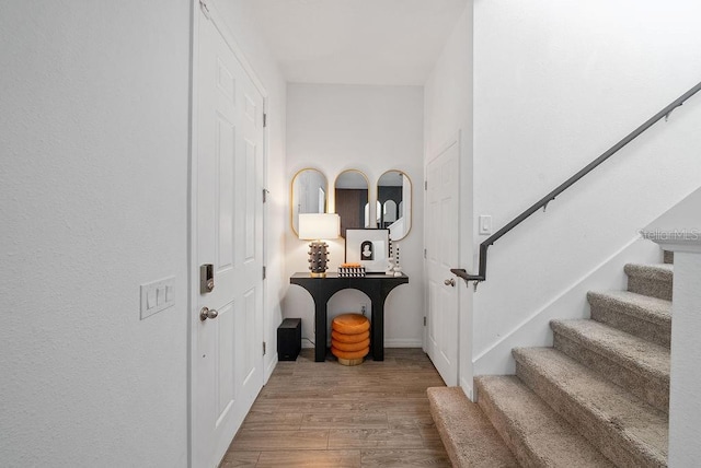 foyer entrance featuring stairs and wood finished floors