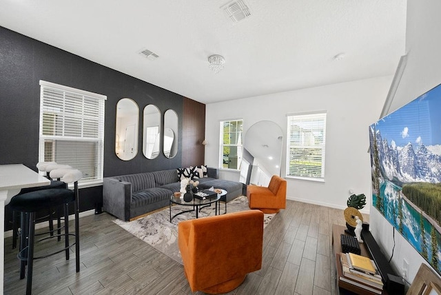 living area with visible vents, baseboards, and wood finished floors