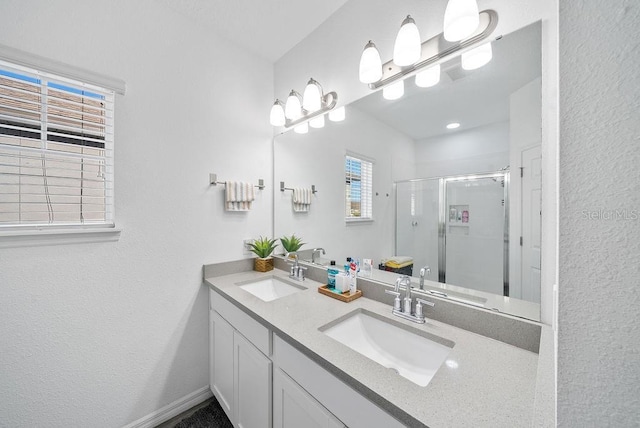 full bath with a stall shower, a sink, and double vanity