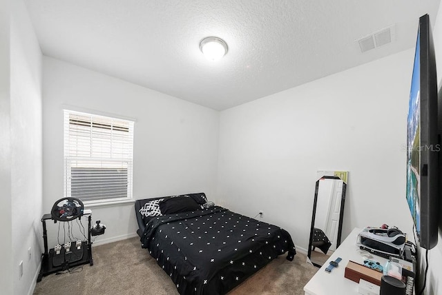 carpeted bedroom with a textured ceiling, visible vents, and baseboards