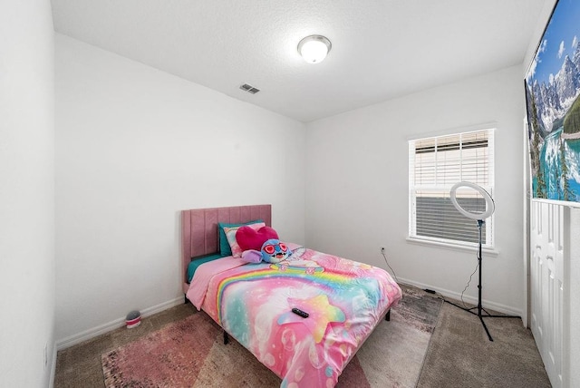 carpeted bedroom with visible vents and baseboards