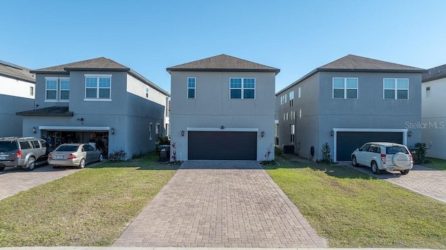 view of front of home with decorative driveway, stucco siding, an attached garage, central AC unit, and a front lawn