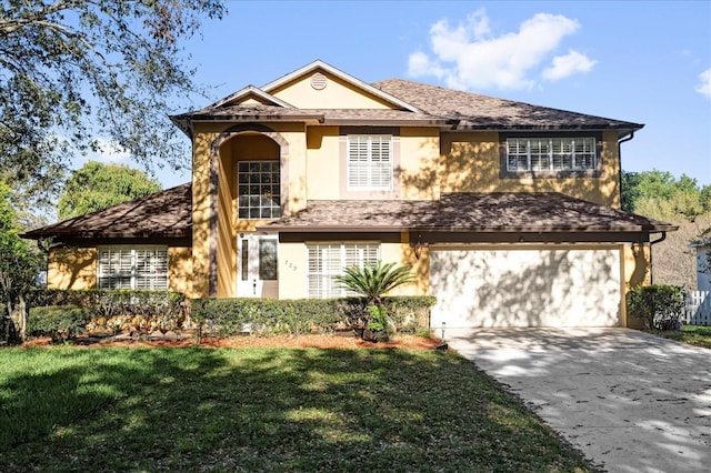 view of front of house with stucco siding, roof with shingles, concrete driveway, a front yard, and a garage