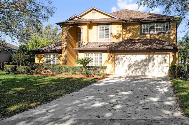 view of front of home featuring stucco siding, driveway, a front yard, a shingled roof, and a garage