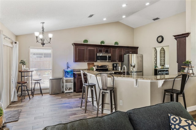 kitchen featuring a breakfast bar, visible vents, and appliances with stainless steel finishes