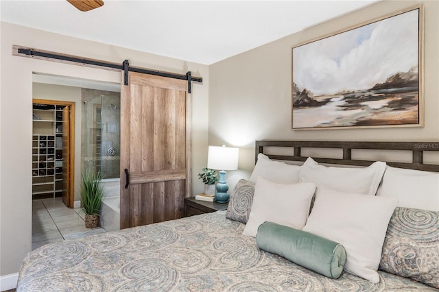 bedroom featuring tile patterned flooring, a spacious closet, and a barn door