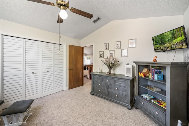 interior space with visible vents, lofted ceiling, light carpet, a textured ceiling, and a ceiling fan