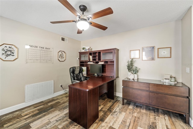 office space featuring a textured ceiling, wood finished floors, visible vents, and ceiling fan