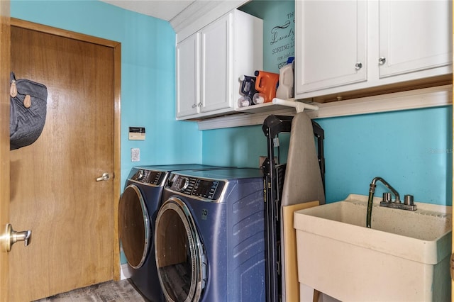 laundry room with light wood finished floors, washing machine and dryer, cabinet space, and a sink