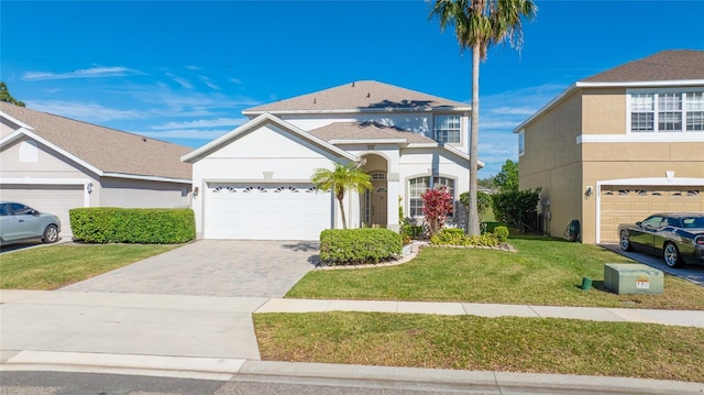 traditional home with an attached garage, a front lawn, decorative driveway, and stucco siding