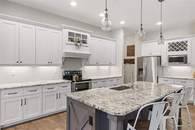 kitchen featuring appliances with stainless steel finishes, a breakfast bar, a sink, and recessed lighting