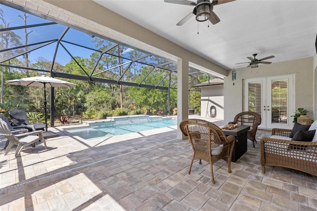 exterior space with an outdoor pool, a ceiling fan, glass enclosure, an outdoor hangout area, and french doors