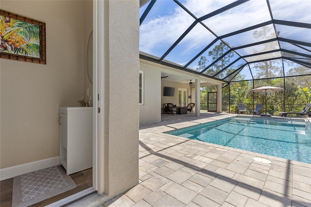 outdoor pool featuring a lanai, a patio area, and ceiling fan