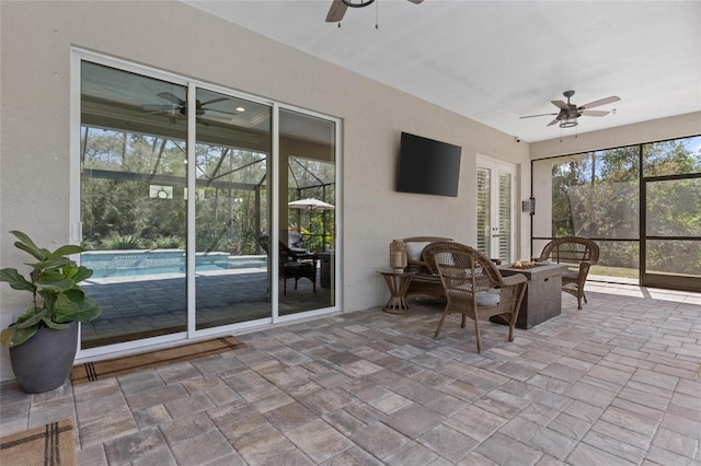 unfurnished sunroom with ceiling fan