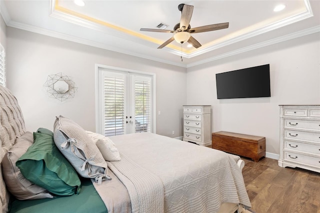 bedroom featuring a tray ceiling, french doors, crown molding, and dark wood-style flooring