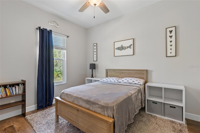 bedroom with ceiling fan, baseboards, and wood finished floors