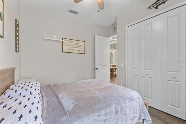 bedroom with ceiling fan, a closet, wood finished floors, and visible vents