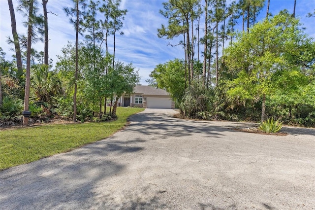 view of front of house featuring driveway, an attached garage, and a front yard