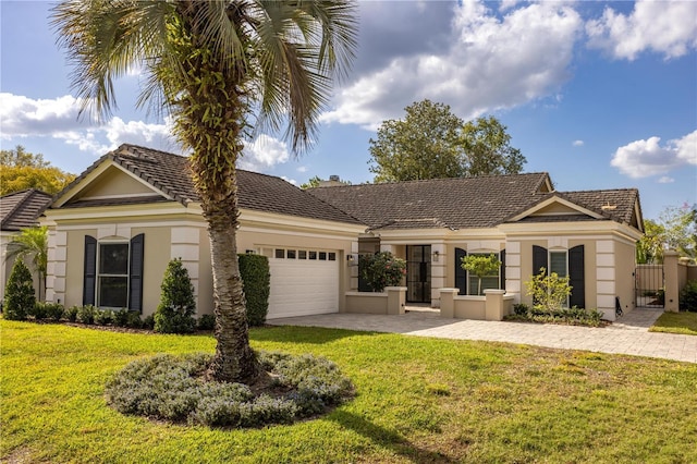 view of front of house with a front lawn, a garage, driveway, and stucco siding