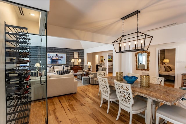 dining area featuring stairs, an inviting chandelier, light wood-style flooring, and visible vents