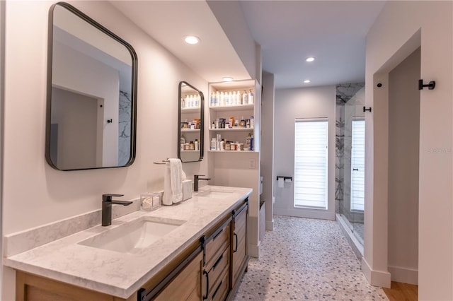 bathroom featuring a shower stall, recessed lighting, double vanity, and a sink