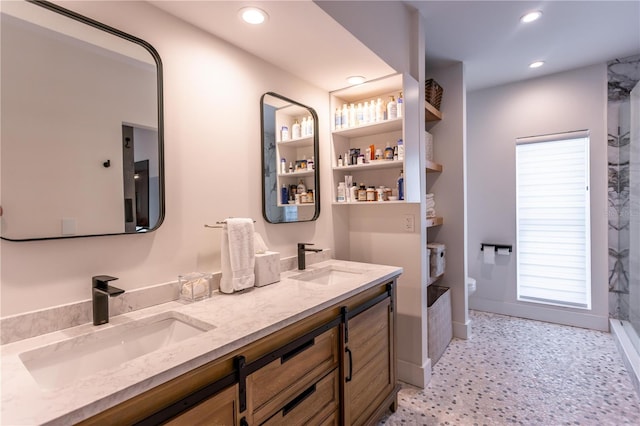 bathroom with double vanity, a shower, recessed lighting, and a sink