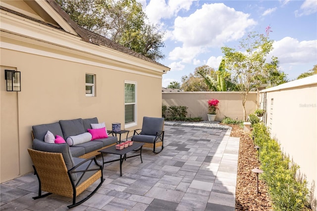 view of patio with an outdoor living space and fence