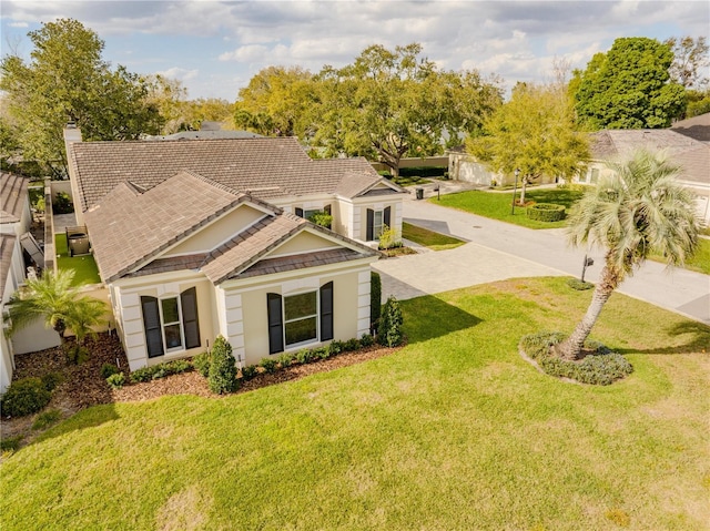 view of front of home with stucco siding, a front lawn, and a tile roof