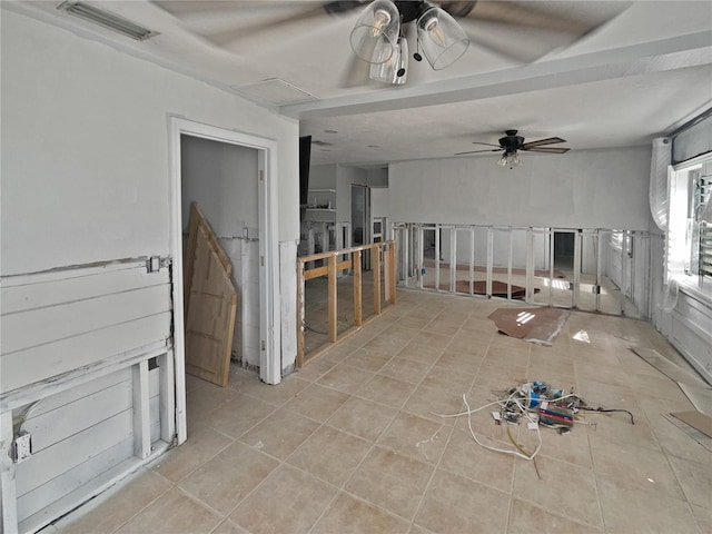 tiled spare room featuring attic access, visible vents, and a ceiling fan