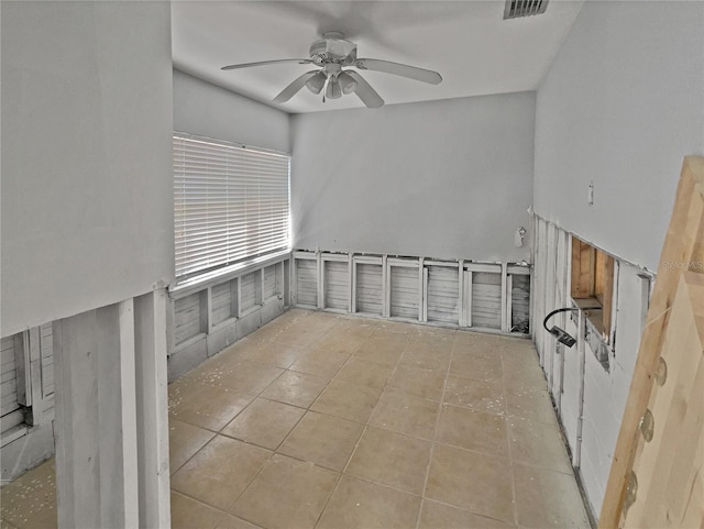 tiled empty room featuring visible vents and a ceiling fan