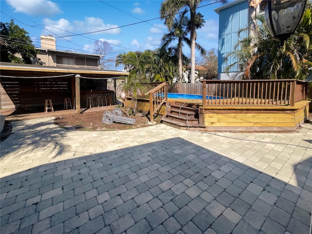 view of patio with a swimming pool and fence