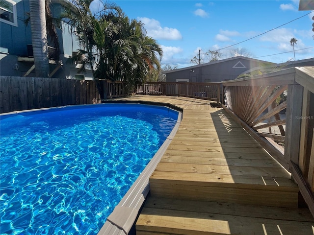 view of swimming pool featuring fence, a deck, and a fenced in pool