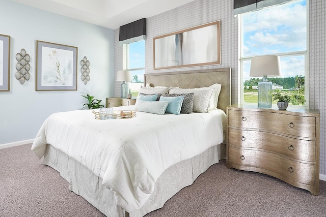 bedroom featuring multiple windows, baseboards, and carpet flooring