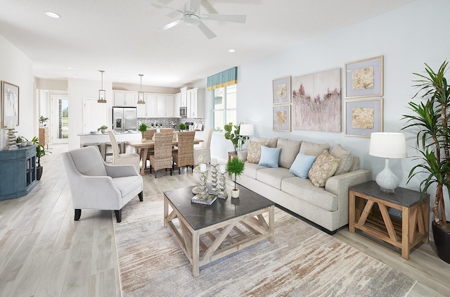 living area featuring a ceiling fan, recessed lighting, and light wood finished floors