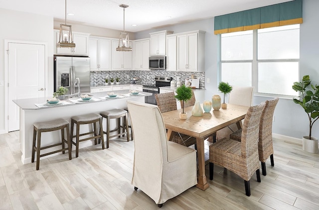 dining room featuring light wood-style floors and baseboards