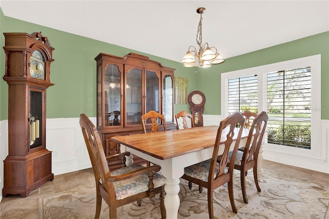 dining area with a notable chandelier and wainscoting