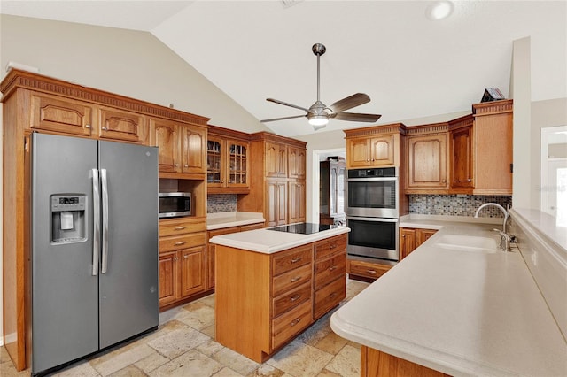 kitchen with brown cabinets, stainless steel appliances, lofted ceiling, and a sink