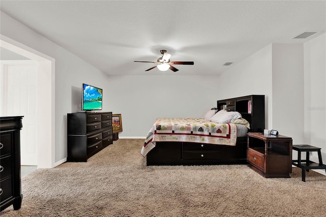 carpeted bedroom with visible vents, baseboards, a textured ceiling, and a ceiling fan