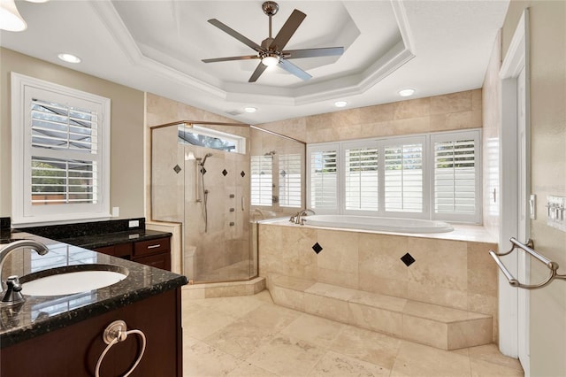 full bathroom featuring a shower stall, a bath, a raised ceiling, ceiling fan, and vanity