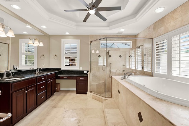 bathroom with a sink, a tray ceiling, a bath, and a shower stall