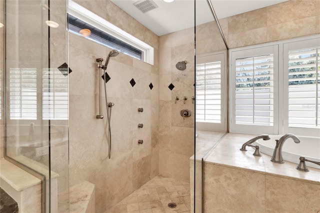 bathroom with a tile shower and visible vents