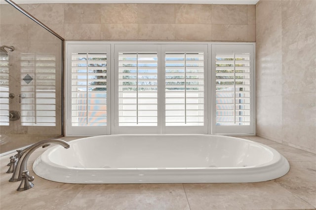 bathroom with tile walls and a tub