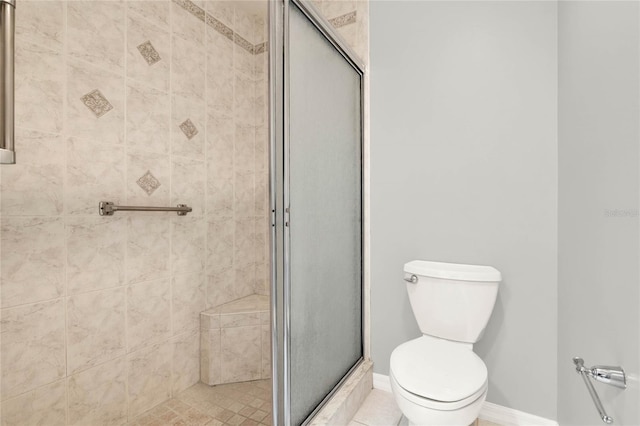 bathroom featuring baseboards, toilet, and a shower stall