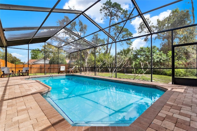 view of swimming pool with a fenced in pool, a patio, a fenced backyard, and glass enclosure