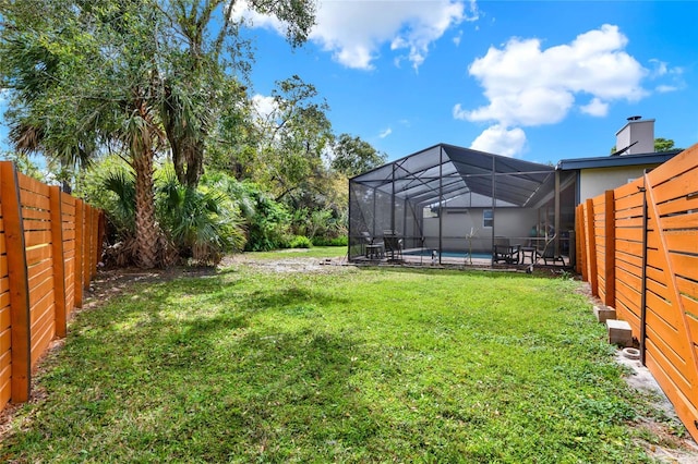 view of yard featuring an outdoor pool, a fenced backyard, and a lanai