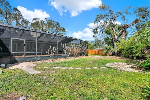 view of yard with a fenced in pool, glass enclosure, and fence