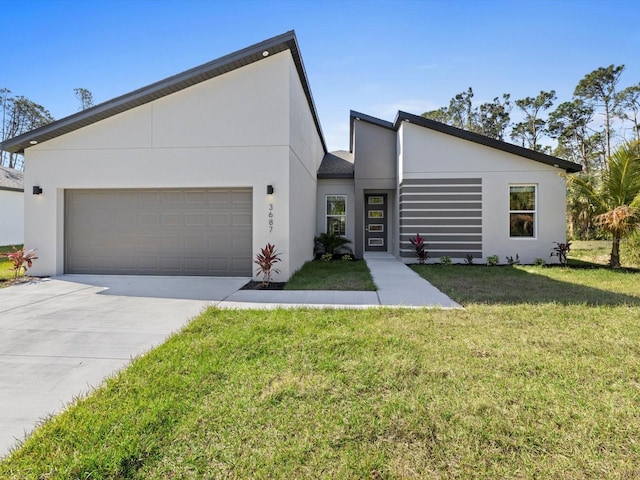 view of front of property with a garage, a front yard, concrete driveway, and stucco siding